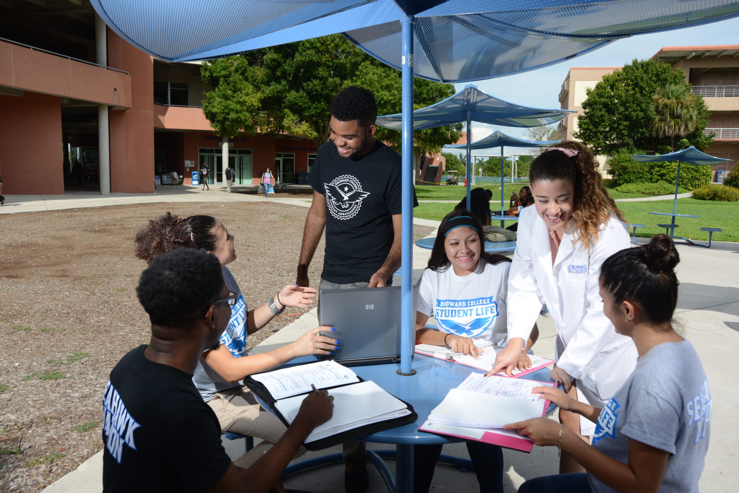 student studying outside at table on campus